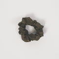A dark olive green fabric scrunchie with a subtle camouflage pattern, centered on a plain white background.